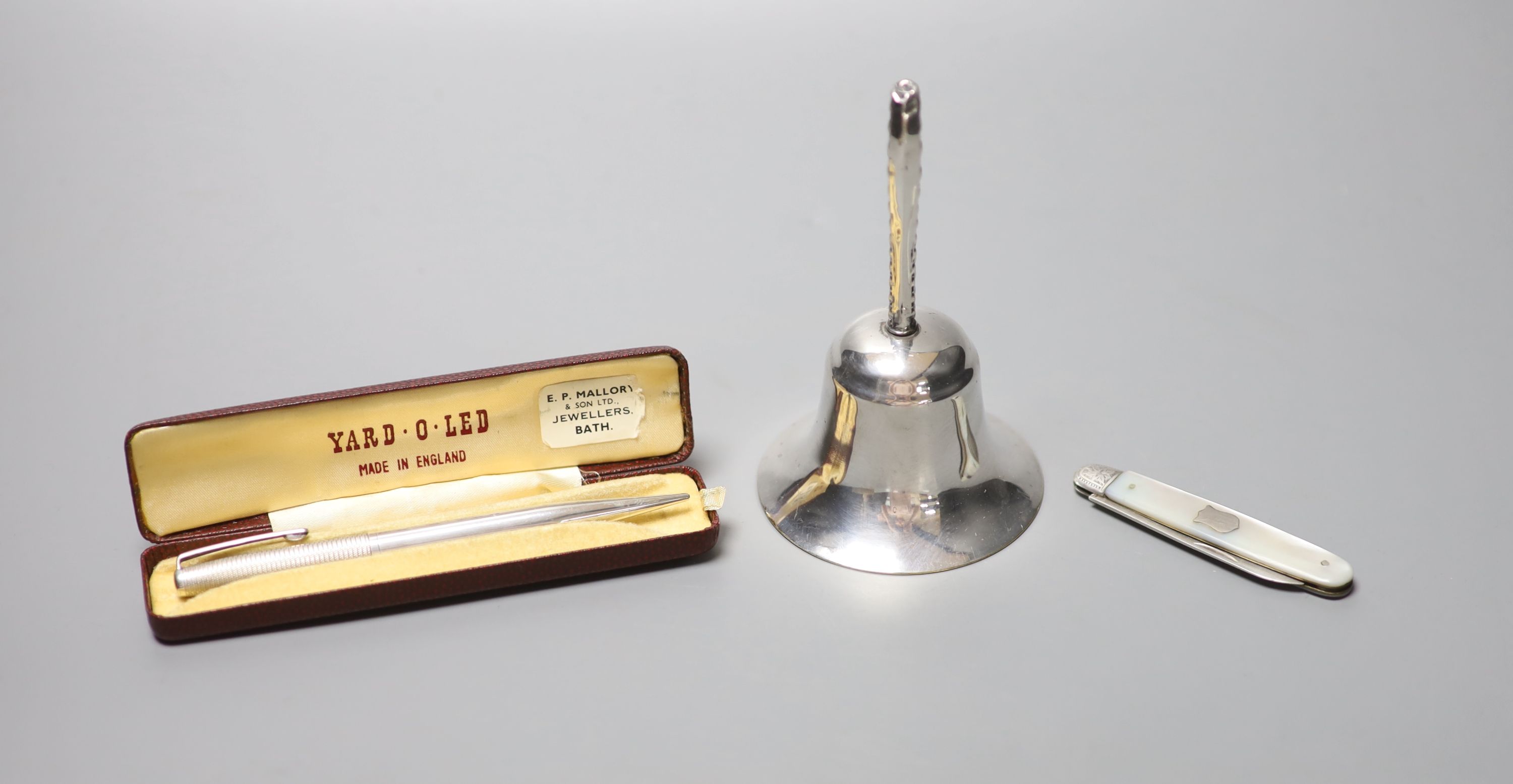 A silver handled bell, 11.5cm, a silver cased Yard-O-Led pen and a mother of pearl handled silver fruit knife.